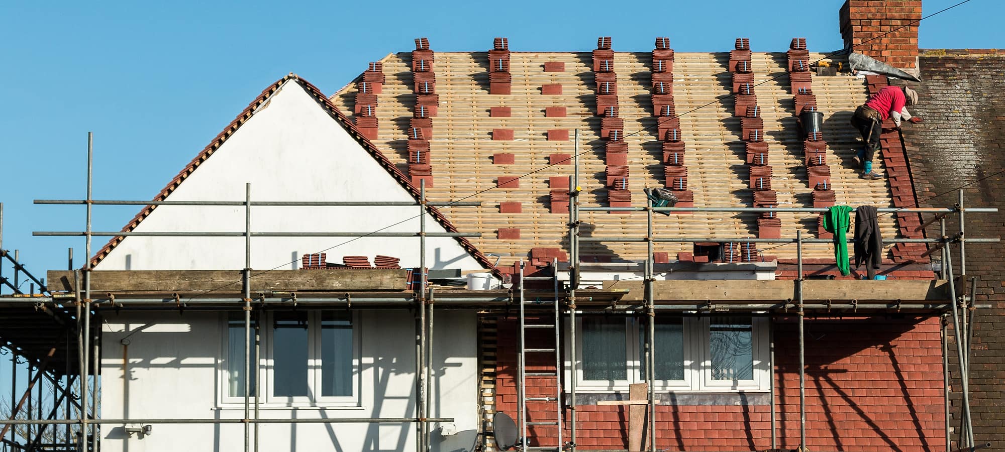 A scaffolded house part way through a full re-roof